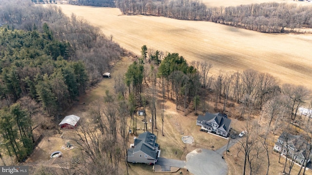 birds eye view of property featuring a rural view and a wooded view