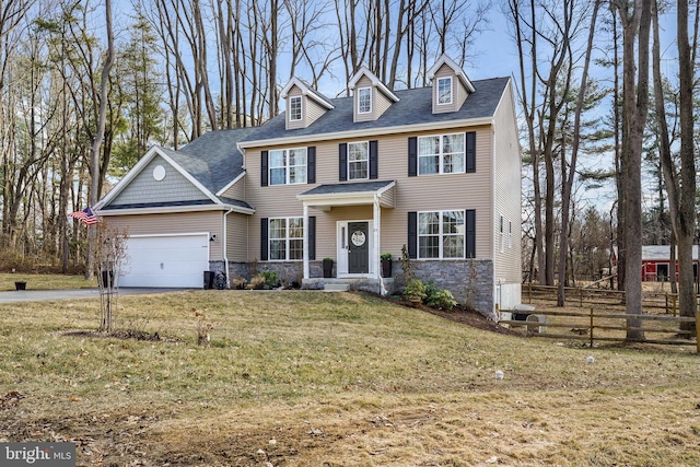 view of front facade featuring concrete driveway, a front yard, fence, a garage, and stone siding