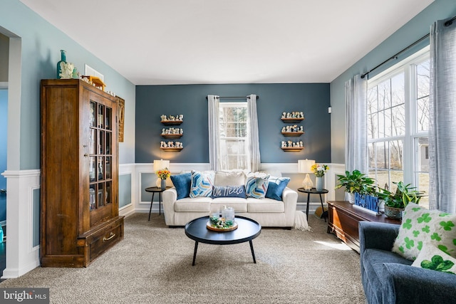 living area with carpet and a wainscoted wall