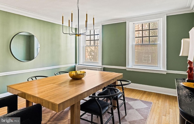 dining room with a healthy amount of sunlight, light wood-style flooring, baseboards, and crown molding