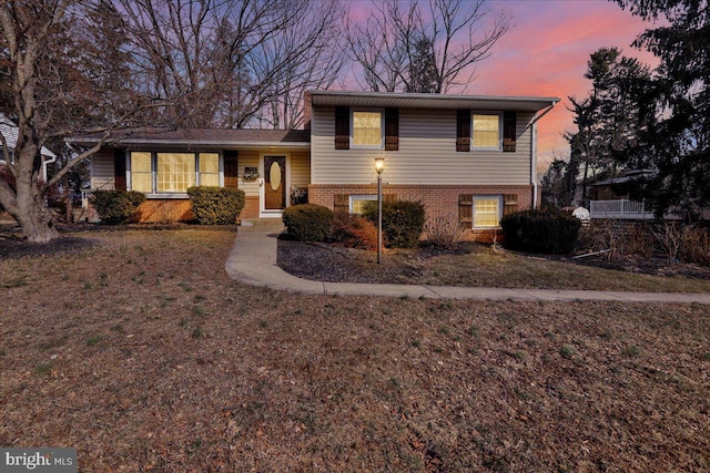 tri-level home featuring brick siding