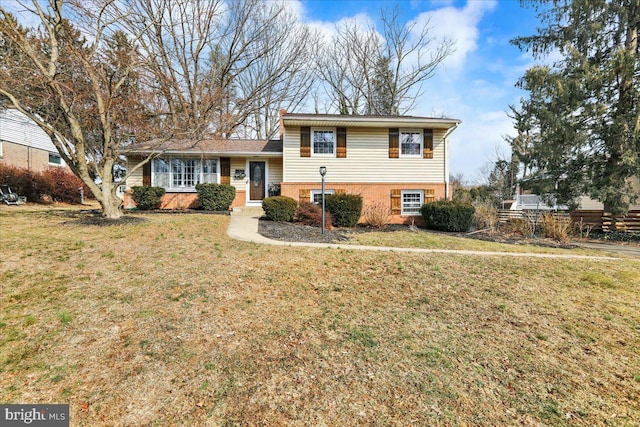 split level home featuring brick siding and a front lawn