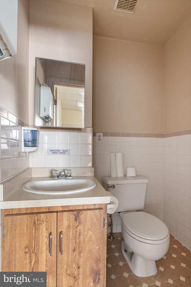 709 E Passyunk Ave, Philadelphia, PA 19147 - half bath featuring toilet, a wainscoted wall, vanity, visible vents, and tile walls