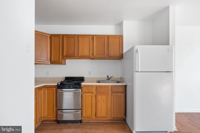 709 E Passyunk Ave, Philadelphia, PA 19147 - kitchen with freestanding refrigerator, light countertops, a sink, and stainless steel range with gas cooktop