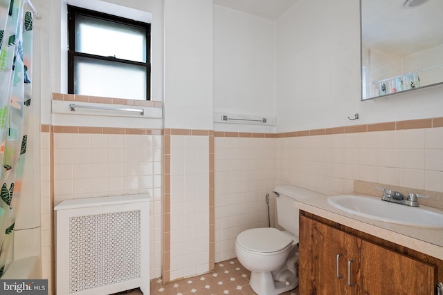709 E Passyunk Ave, Philadelphia, PA 19147 - full bathroom featuring toilet, vanity, tile walls, wainscoting, and radiator heating unit