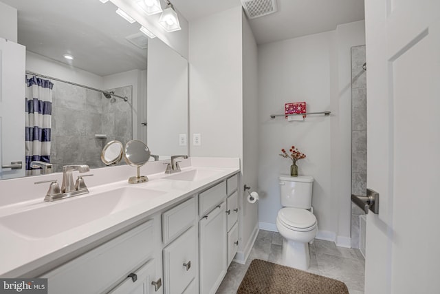 full bathroom featuring toilet, visible vents, a tile shower, and a sink