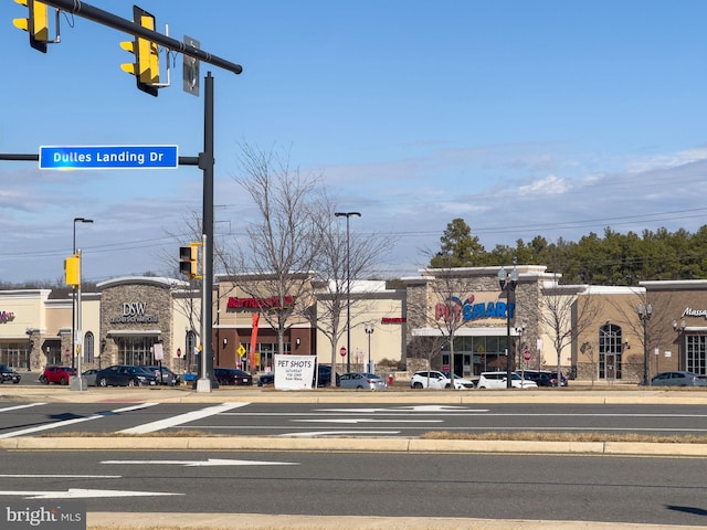 view of street with street lights, curbs, traffic lights, and sidewalks