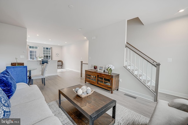 living area featuring recessed lighting, visible vents, light wood-style flooring, and baseboards