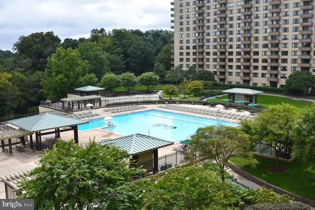 community pool with fence and a gazebo