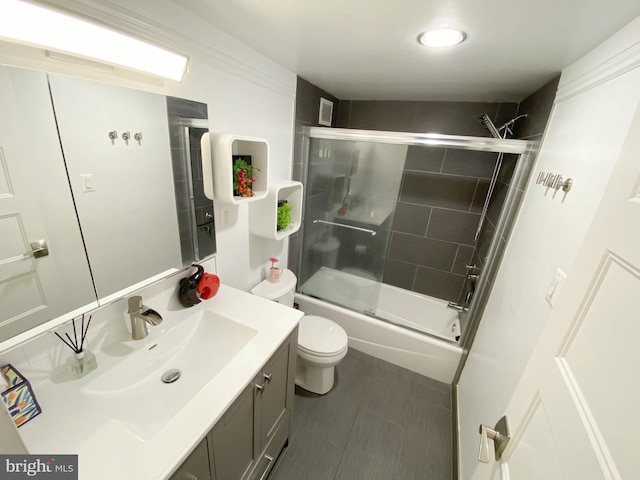 bathroom with visible vents, combined bath / shower with glass door, vanity, and toilet