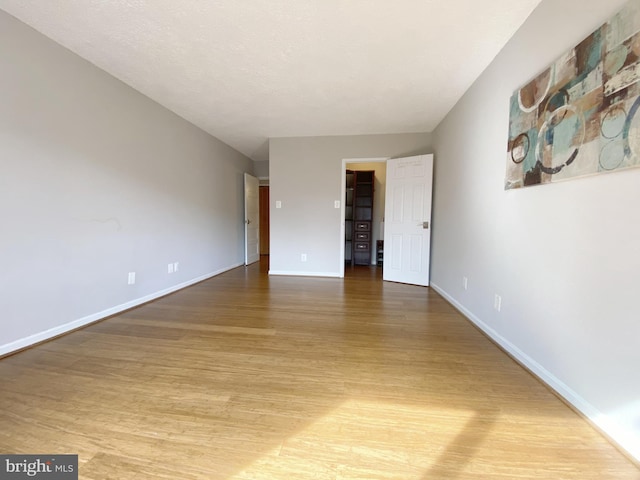 empty room featuring light wood-style flooring and baseboards