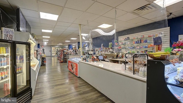 interior space featuring visible vents, a drop ceiling, and wood finished floors