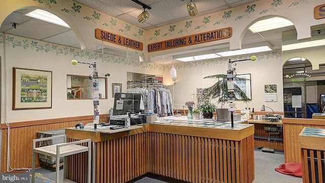 kitchen featuring wainscoting, wooden walls, and track lighting