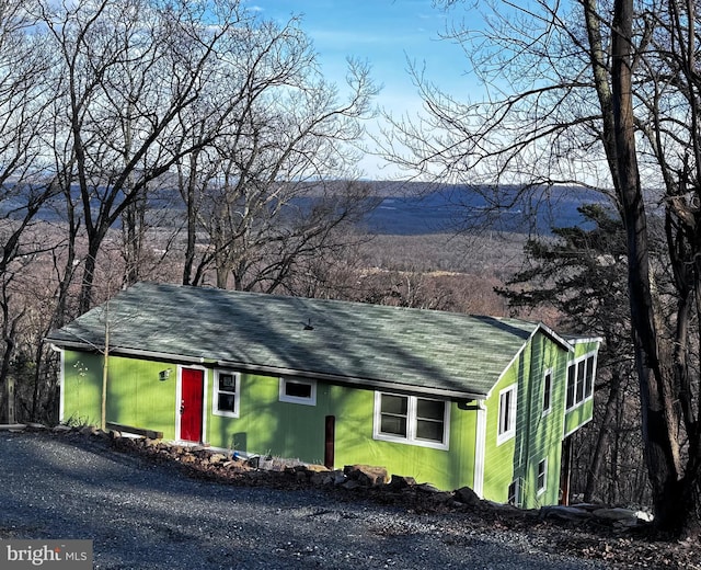 view of front of house with a chimney and gravel driveway