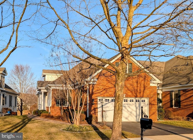 view of front of home featuring a front lawn, brick siding, driveway, and an attached garage