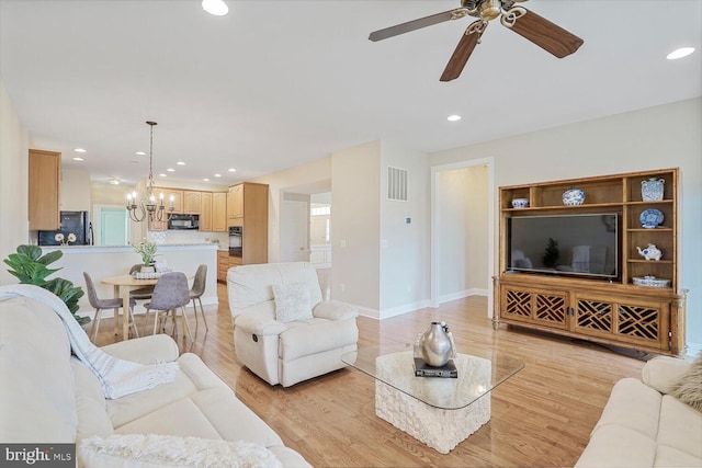 living area featuring recessed lighting, visible vents, light wood-type flooring, baseboards, and ceiling fan with notable chandelier