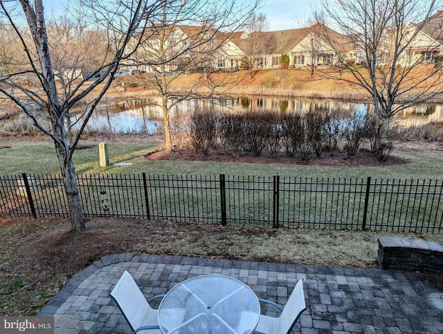 view of yard with a water view, fence, and a patio