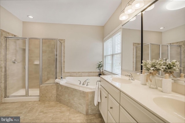 bathroom featuring a stall shower, tile patterned flooring, a garden tub, and a sink