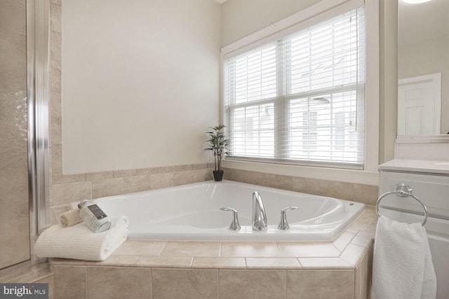 full bath featuring a garden tub, plenty of natural light, and vanity