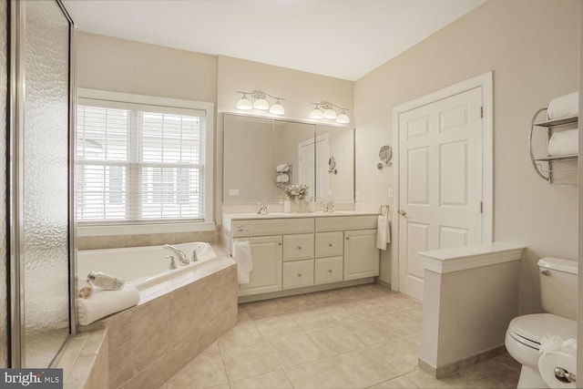 bathroom with toilet, double vanity, a sink, and a bath