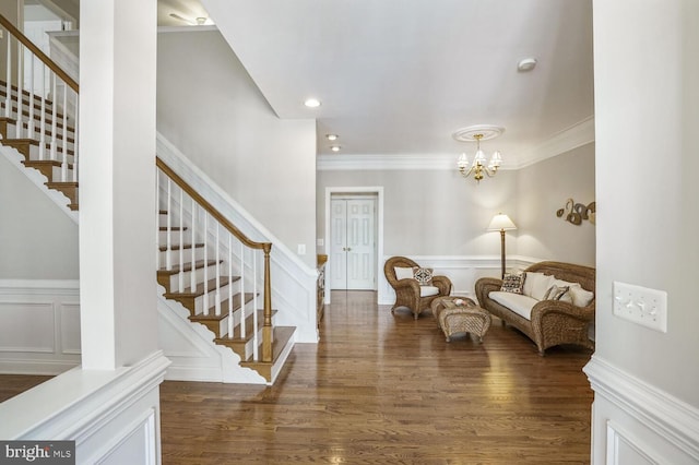 entrance foyer with crown molding, stairway, and wood finished floors