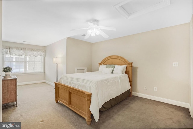 bedroom with attic access, light colored carpet, ceiling fan, and baseboards