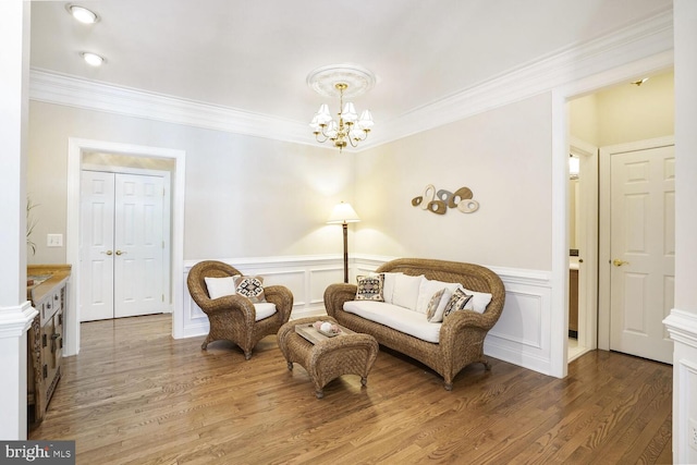 sitting room featuring ornamental molding, light wood-type flooring, and wainscoting