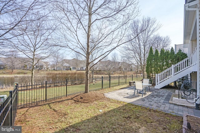 view of yard with a fenced backyard, stairway, and a patio