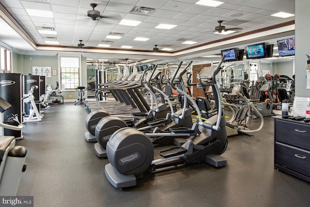 exercise room featuring ceiling fan, ornamental molding, a paneled ceiling, and visible vents