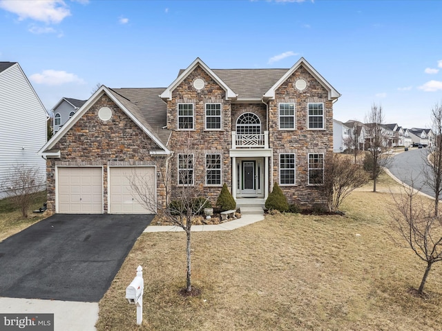 traditional-style home featuring a garage, driveway, and a front lawn