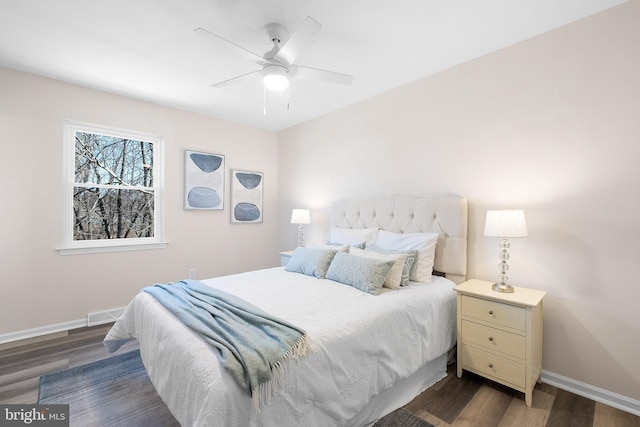 bedroom featuring visible vents, a ceiling fan, baseboards, and dark wood-style flooring