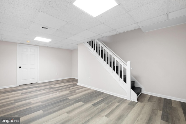 finished basement with stairway, baseboards, and wood finished floors