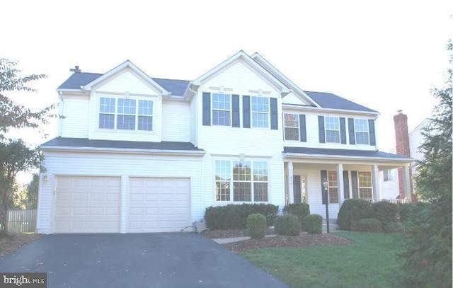 view of front of home with an attached garage, covered porch, and aphalt driveway