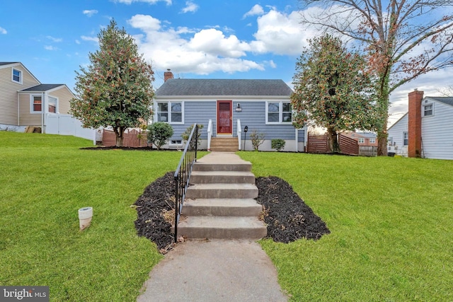 view of front of house featuring a shingled roof, a chimney, fence, and a front yard