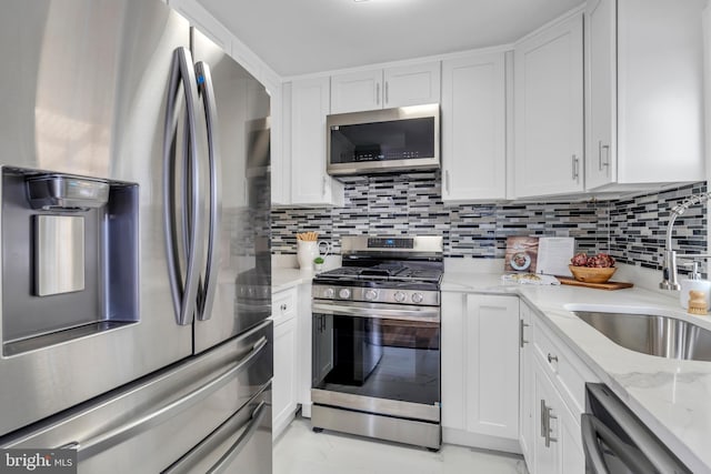 kitchen featuring stainless steel appliances, a sink, and white cabinetry