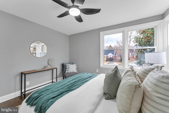 bedroom with ceiling fan, baseboards, and dark wood-style flooring