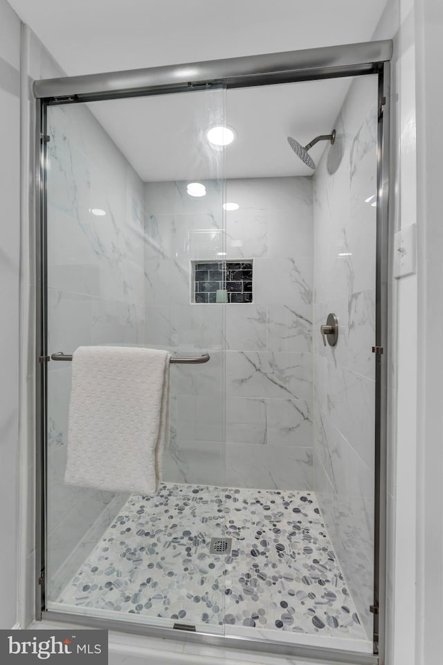 bathroom with a marble finish shower