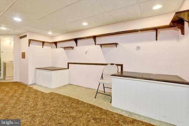 interior space featuring a paneled ceiling, light floors, and recessed lighting