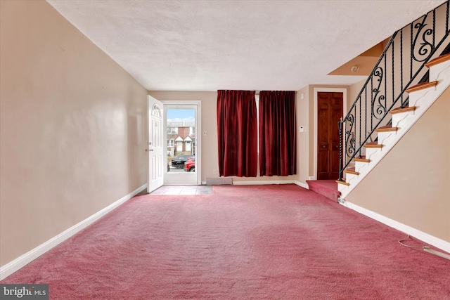 unfurnished living room with stairs, baseboards, and carpet flooring