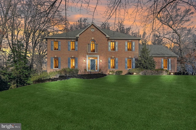 georgian-style home with a front lawn and brick siding