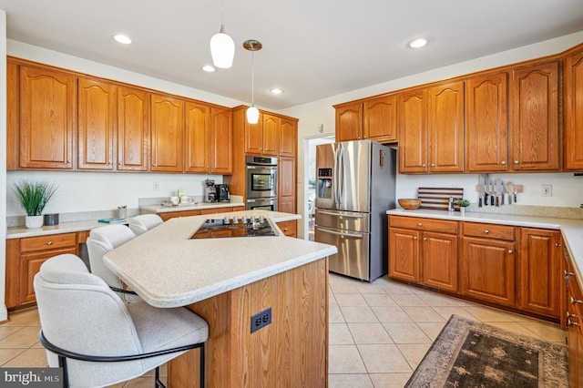 kitchen featuring light tile patterned floors, a kitchen island, hanging light fixtures, appliances with stainless steel finishes, and light countertops