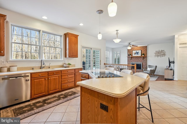 kitchen with dishwasher, open floor plan, a center island, light countertops, and a sink