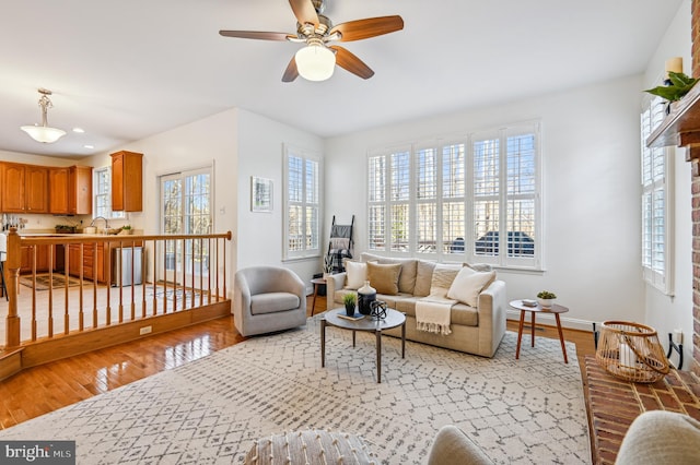 living area with ceiling fan, light wood finished floors, recessed lighting, and baseboards