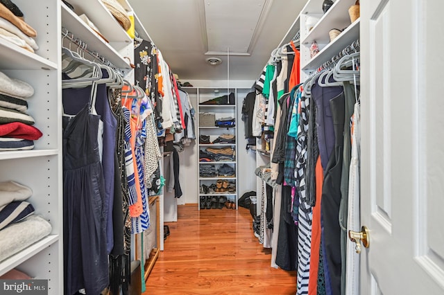 walk in closet featuring visible vents, wood finished floors, and attic access