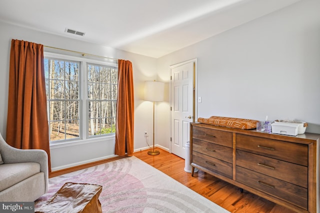 living area with baseboards, visible vents, and light wood finished floors