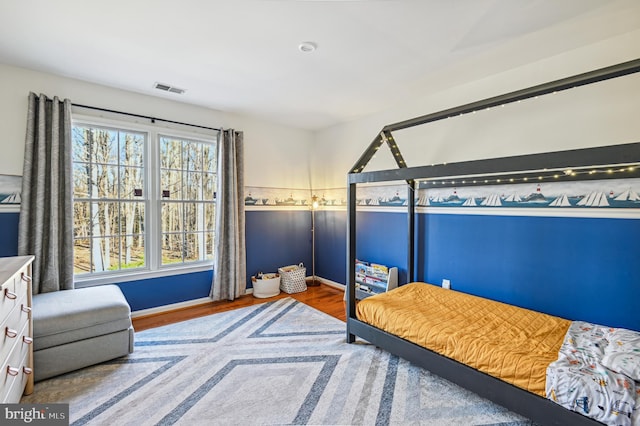 bedroom featuring wood finished floors and visible vents