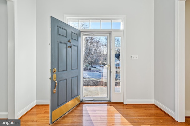 entryway with light wood finished floors and baseboards