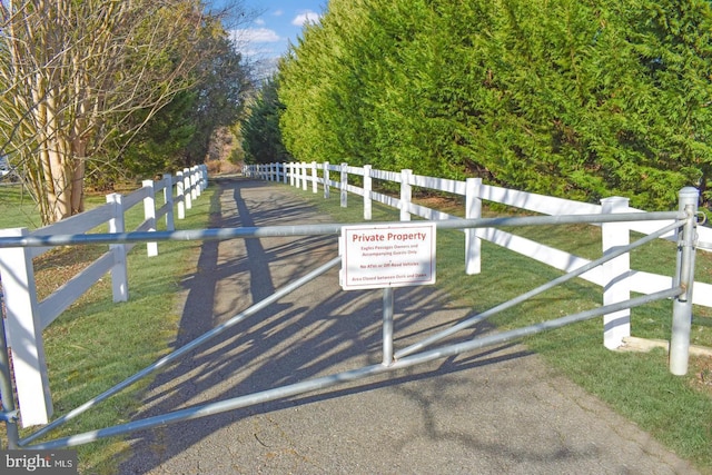 view of gate with fence and a lawn