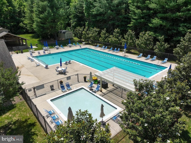 pool with a patio and fence