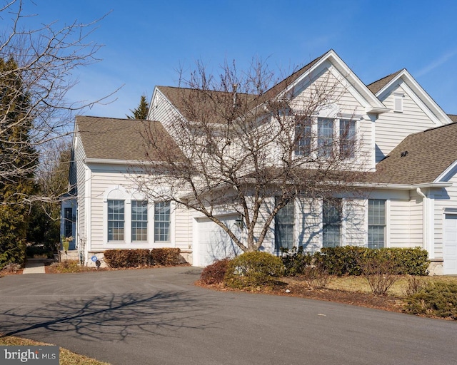 view of front of home featuring aphalt driveway and roof with shingles